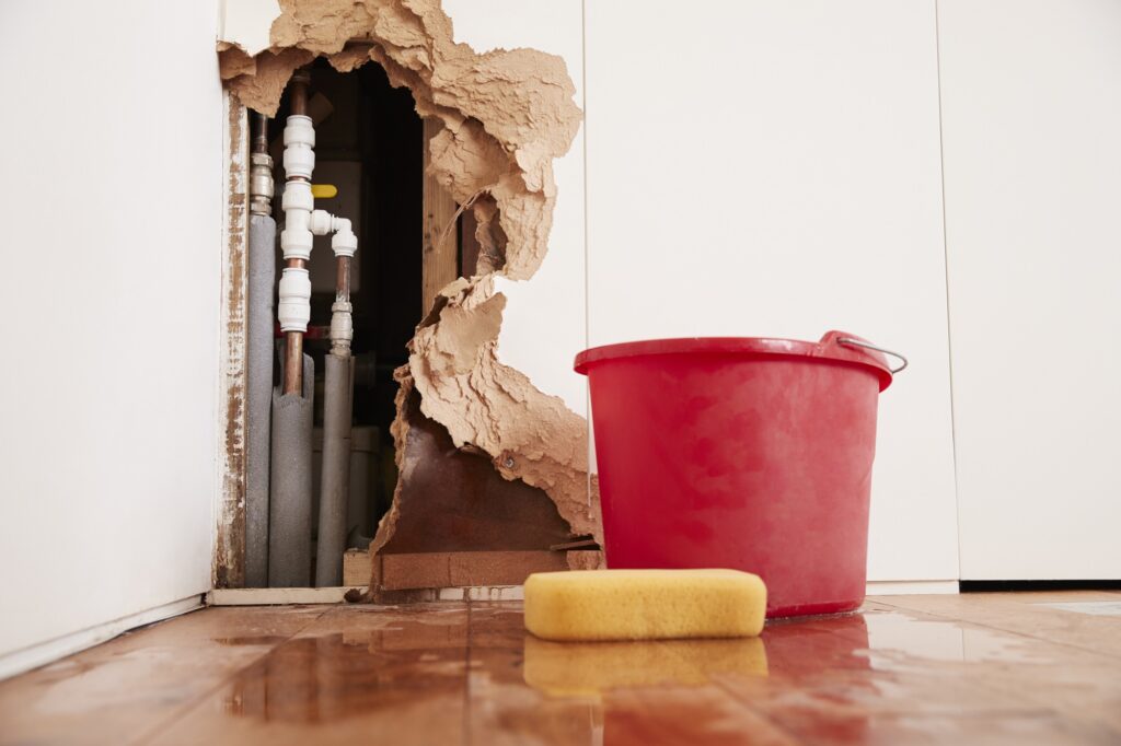 Damaged wall, exposed burst water pipes