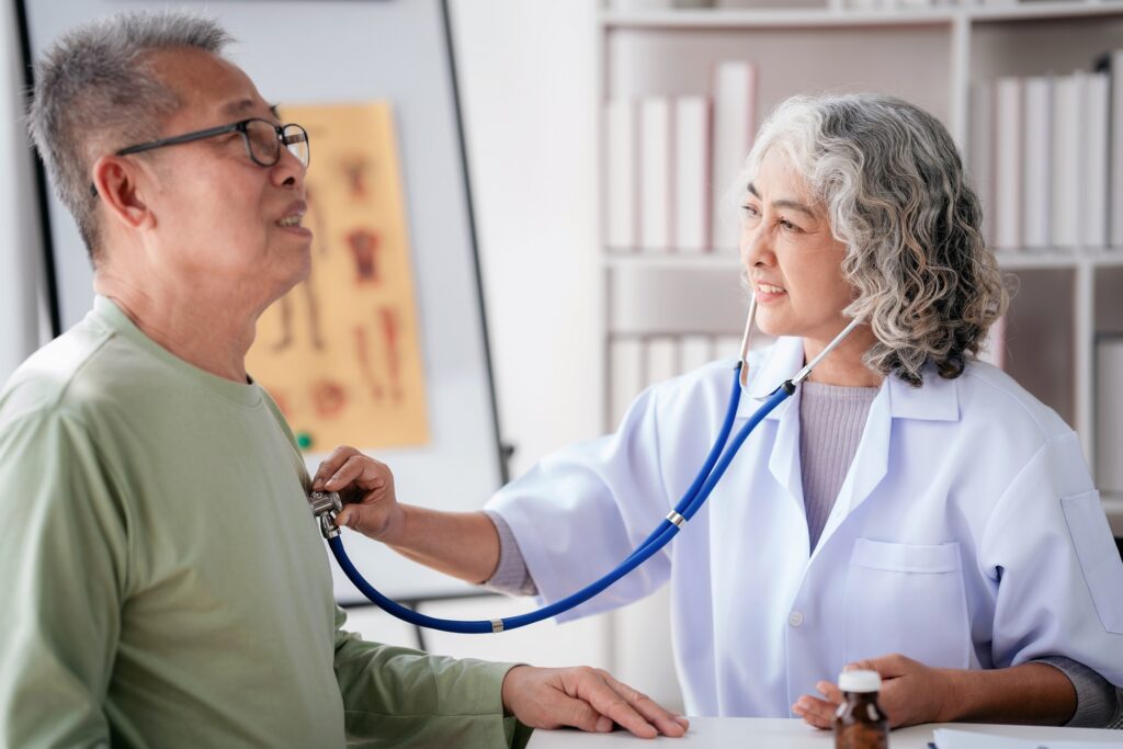 Female doctor using stethoscope to listening heart rate of senio