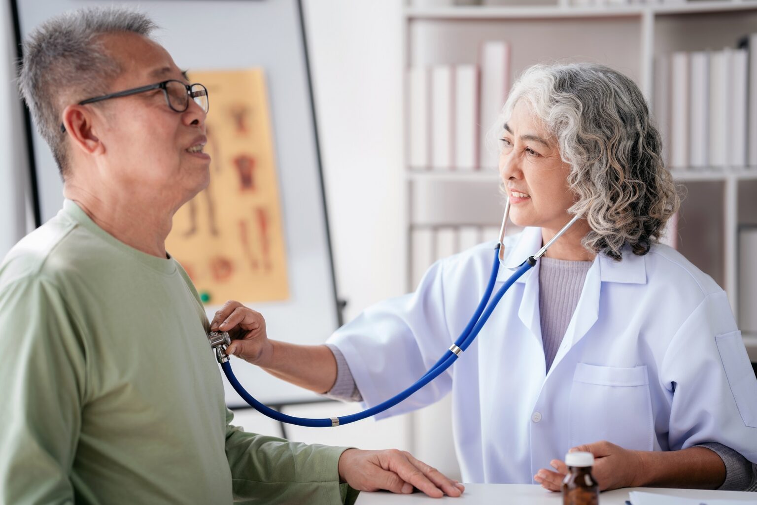 Female doctor using stethoscope to listening heart rate of senio